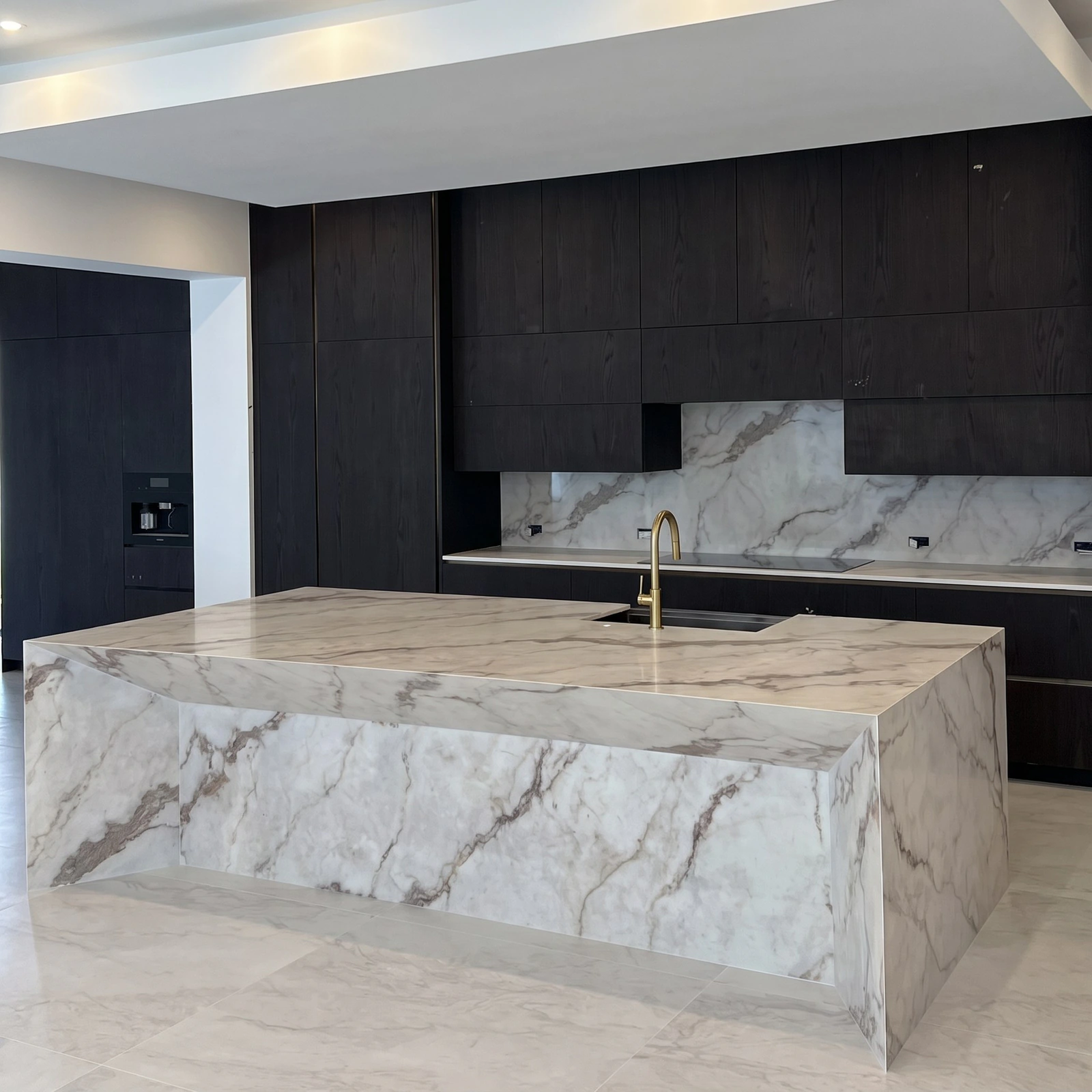 Dark-oak kitchen with a mitered Dekton island