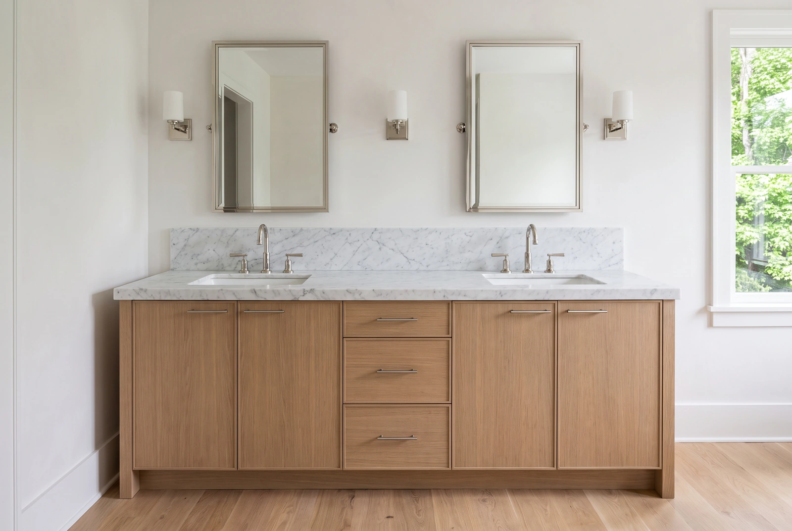 Primary bath with a white oak double vanity and a honed white Carrara marble top