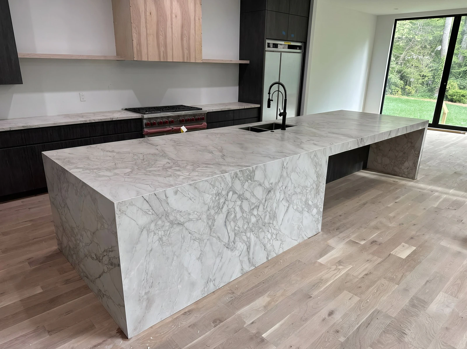 Stone waterfall island in a modern main kitchen