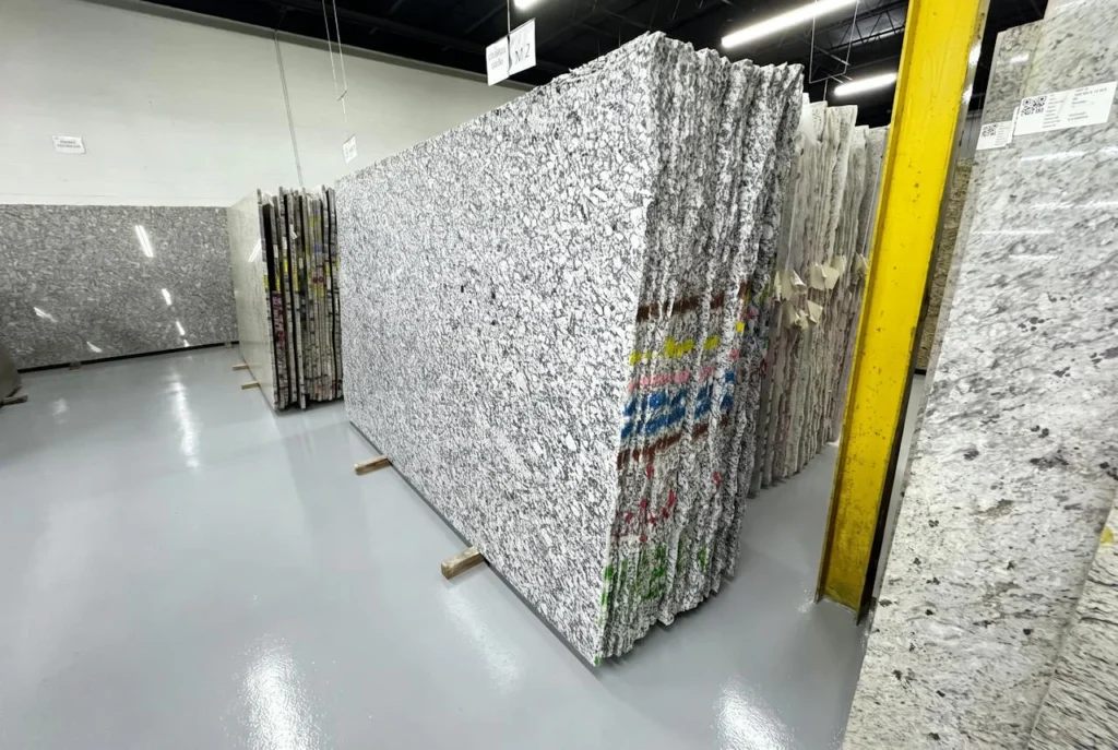 Bundles of polished granite slabs on racks in the GA Granite Atlanta warehouse