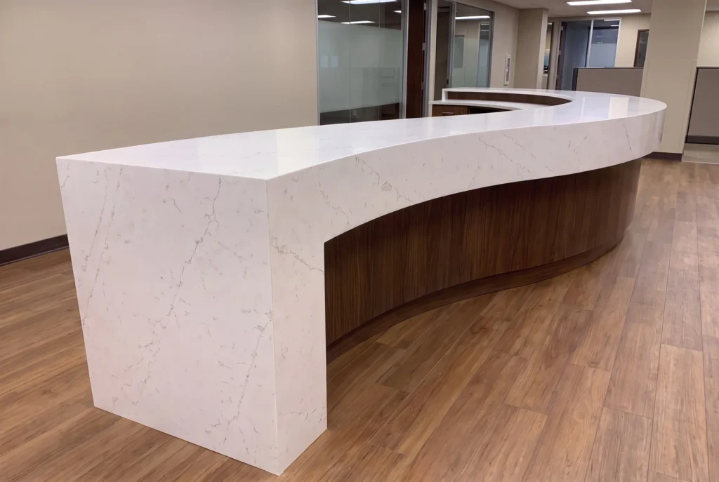 Curved service counter with a thermoformed quartz top, curved front band and quartz waterfall leg